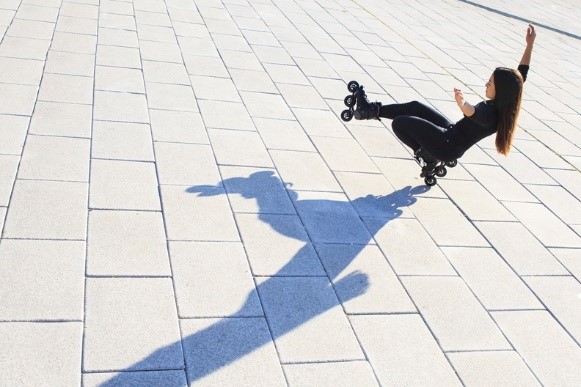 A girl who demonstrates her Powerslide HC EVO inline skates with a wheelie